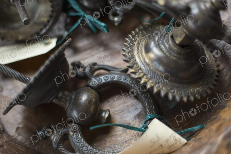 An antique store with a display of objects and furniture from the past. Chased metal…