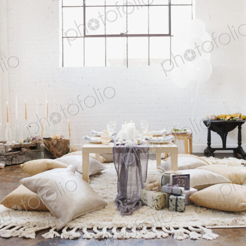 An apartment with a table set for a celebration meal. Cushions on the floor. An apartment with a table set for a celebration meal. Cushions on the floor.