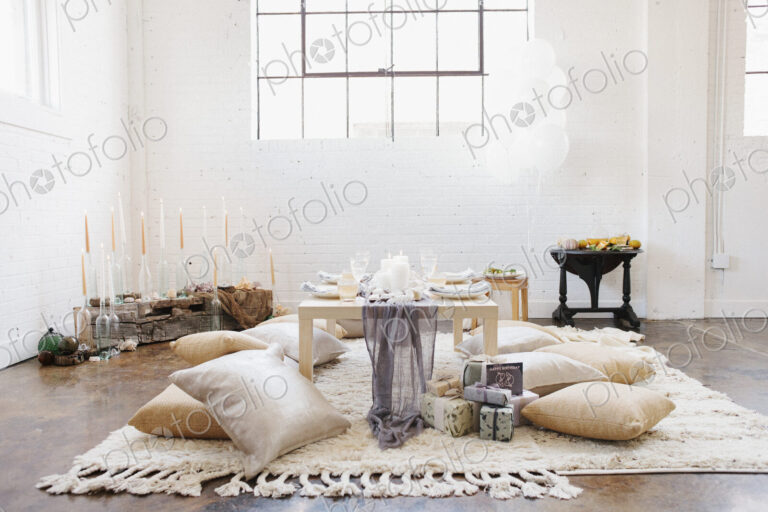An apartment with a table set for a celebration meal. Cushions on the floor.