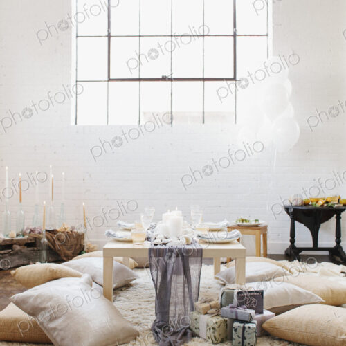 An apartment with a table set for a celebration meal. Cushions on the floor. An apartment with a table set for a celebration meal. Cushions on the floor.
