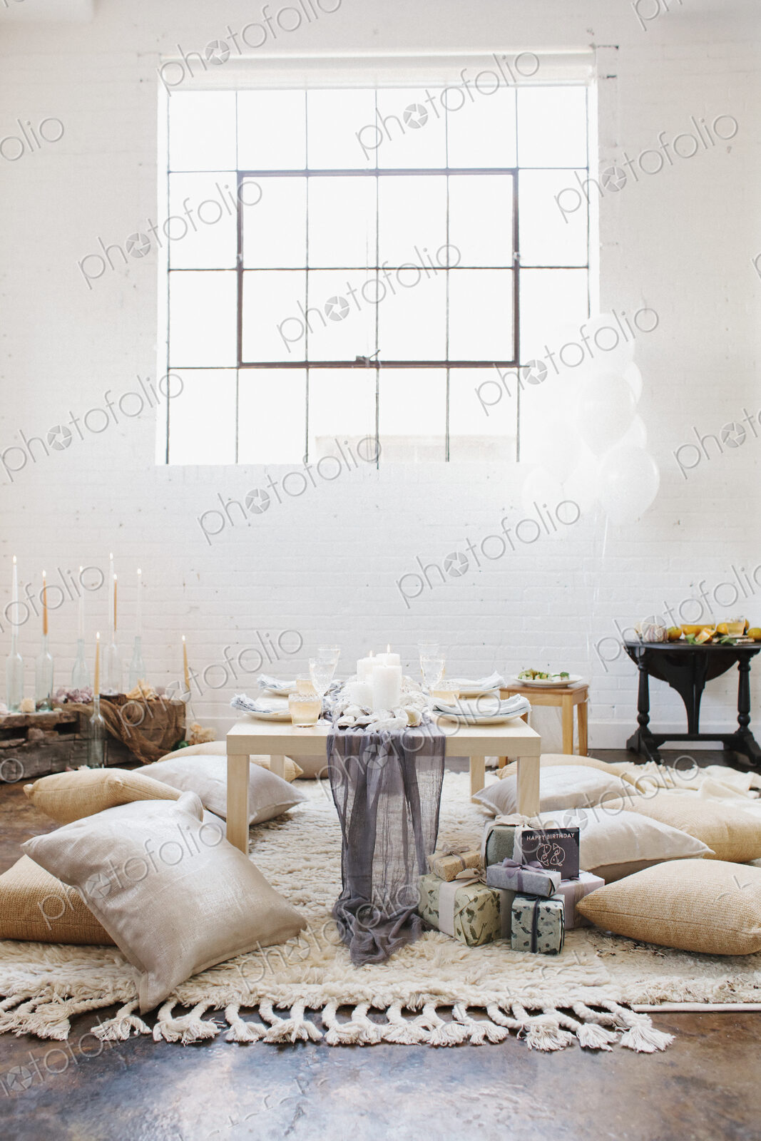 An apartment with a table set for a celebration meal. Cushions on the floor.