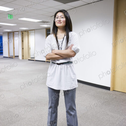 An asian businesswoman stanidng alone in her office space. An asian businesswoman stanidng alone in her office space.