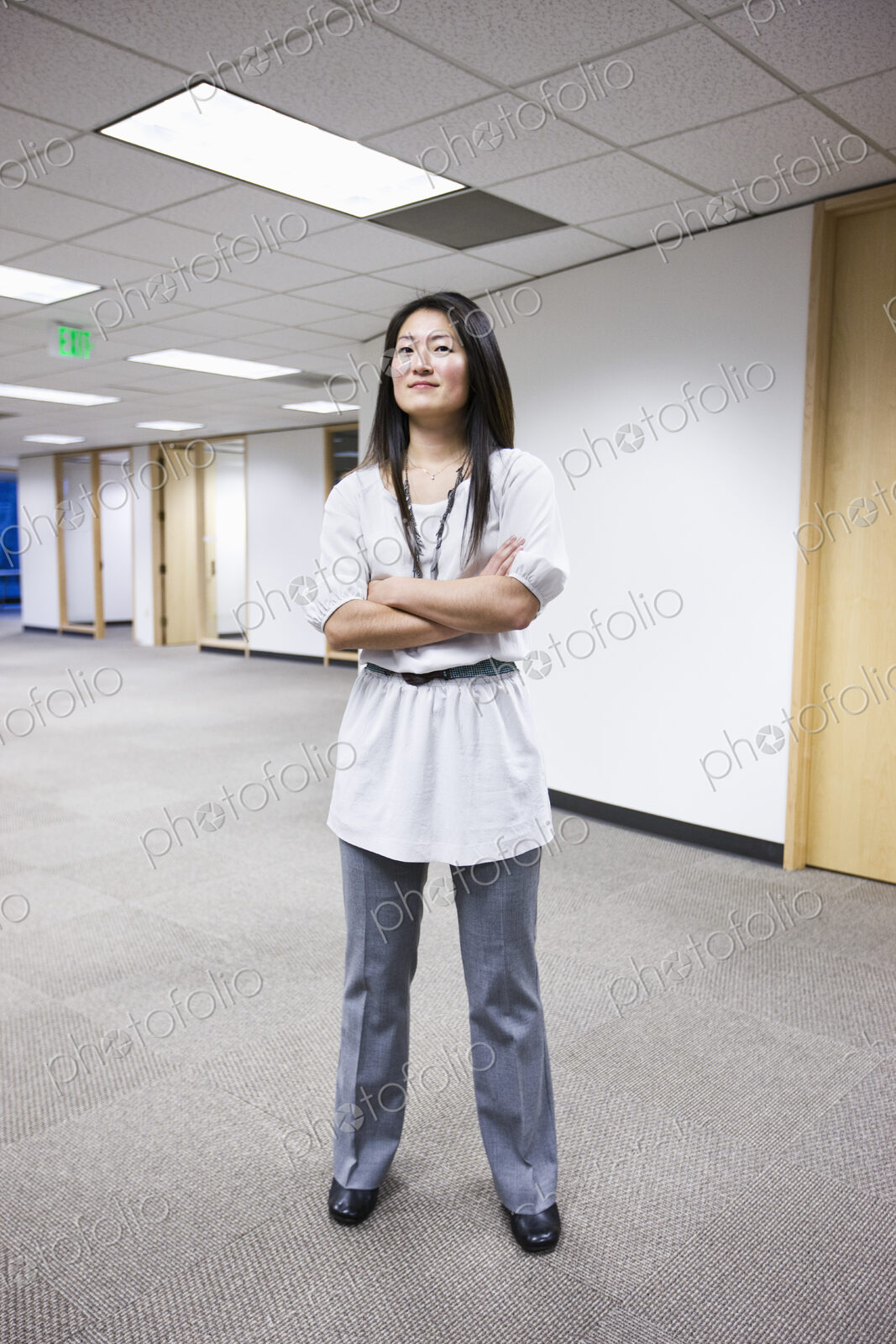 An asian businesswoman stanidng alone in her office space.