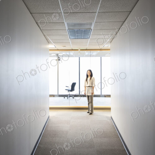 An asian businesswoman stanidng alone in her office space. An asian businesswoman stanidng alone in her office space.