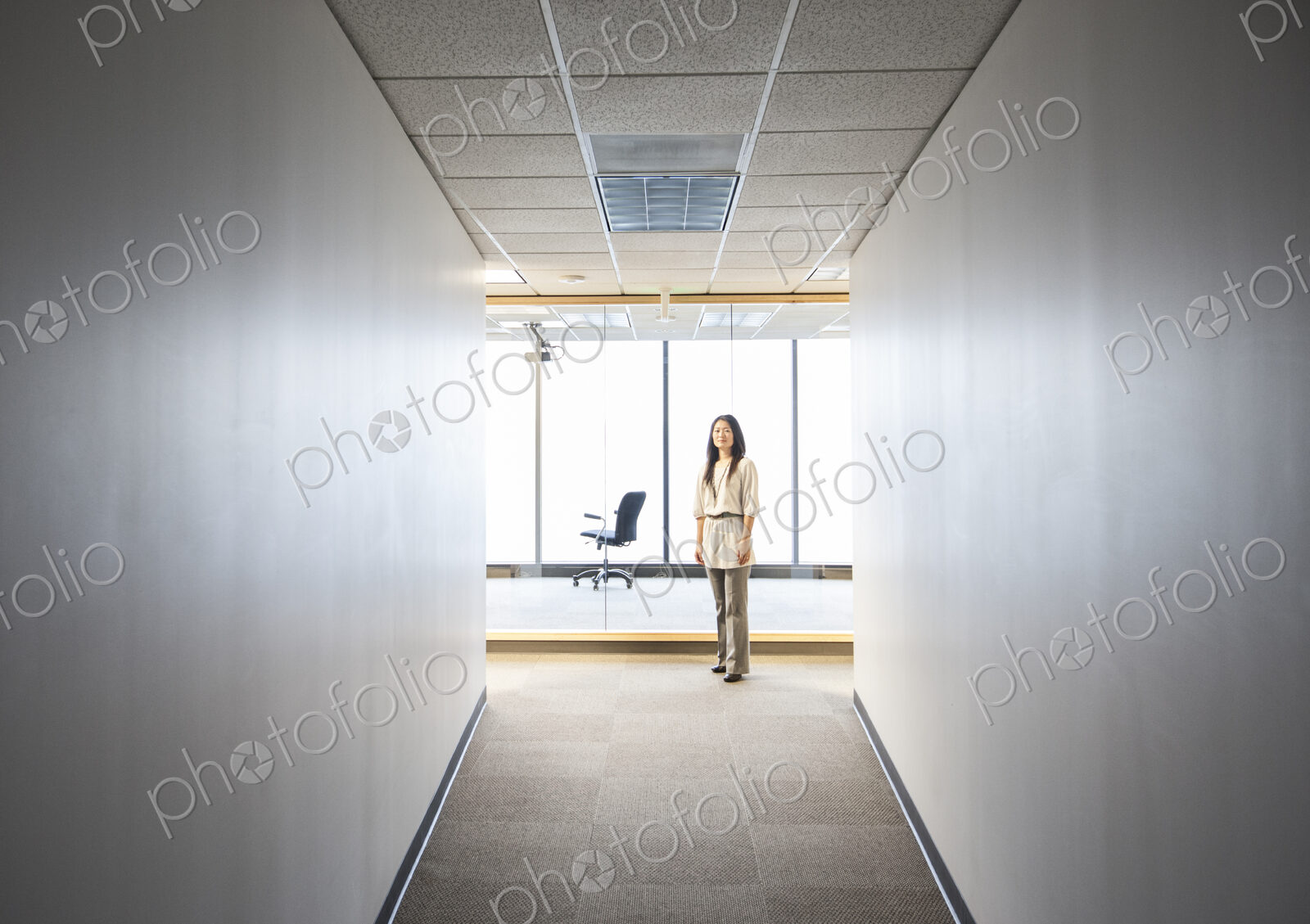 An asian businesswoman stanidng alone in her office space.