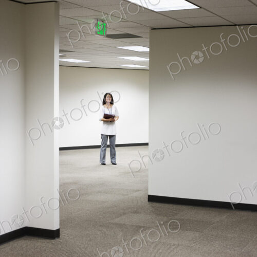 An asian businesswoman stanidng alone in her office space. An asian businesswoman stanidng alone in her office space.