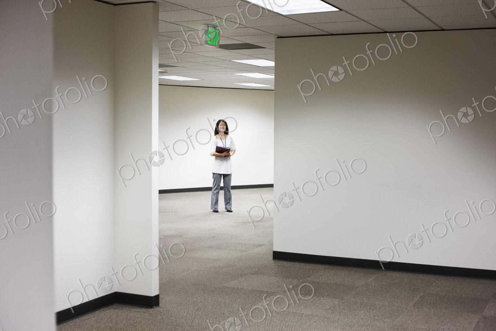 An asian businesswoman stanidng alone in her office space.