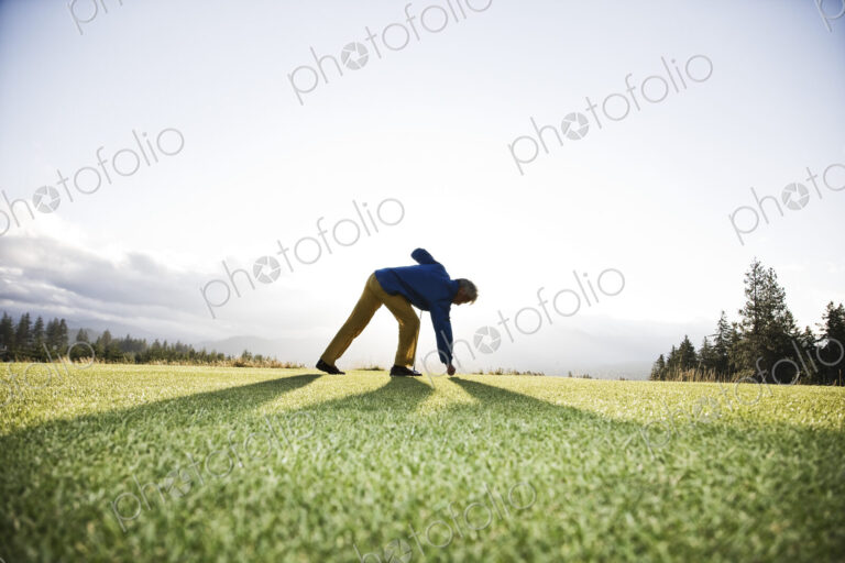 An asian senior man teeing up a golf ball and ready to swing.