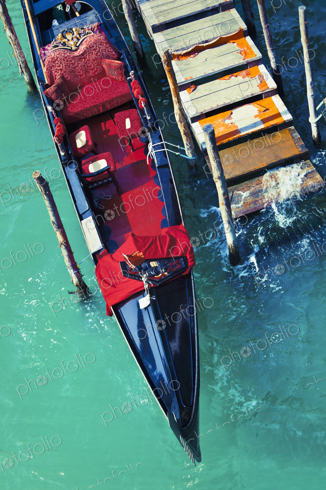 An empty gondola docked at a worn out pier in the city of Venice, Italy.