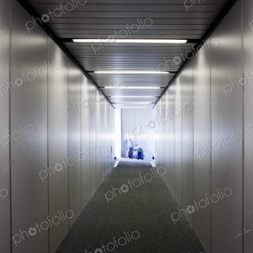 An empty narrow tunnel or corridor, a passenger airbridge.