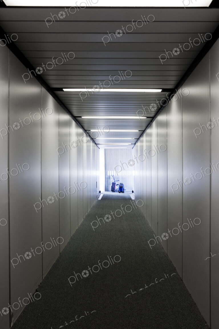 An empty narrow tunnel or corridor, a passenger airbridge.