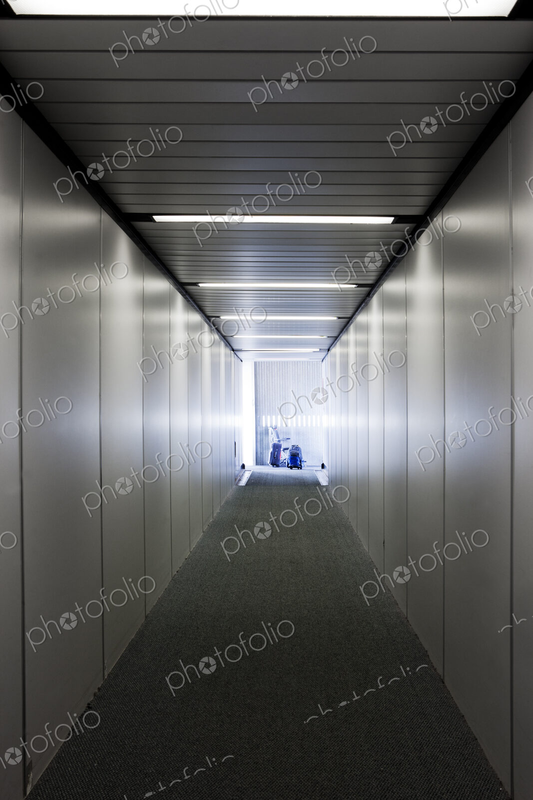 An empty narrow tunnel or corridor, a passenger airbridge.