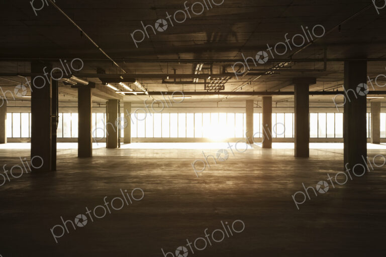 An empty raw business space ready for occupancy. Low light coming in the windows, lens…