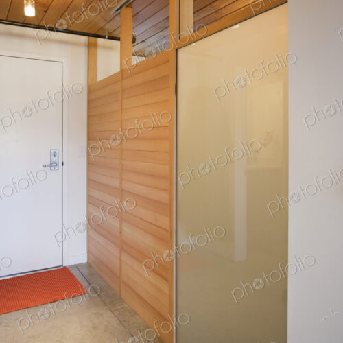 An empty room with a door and wooden partition with glass panes, and lights An empty room with a door and wooden partition with glass panes, and lights