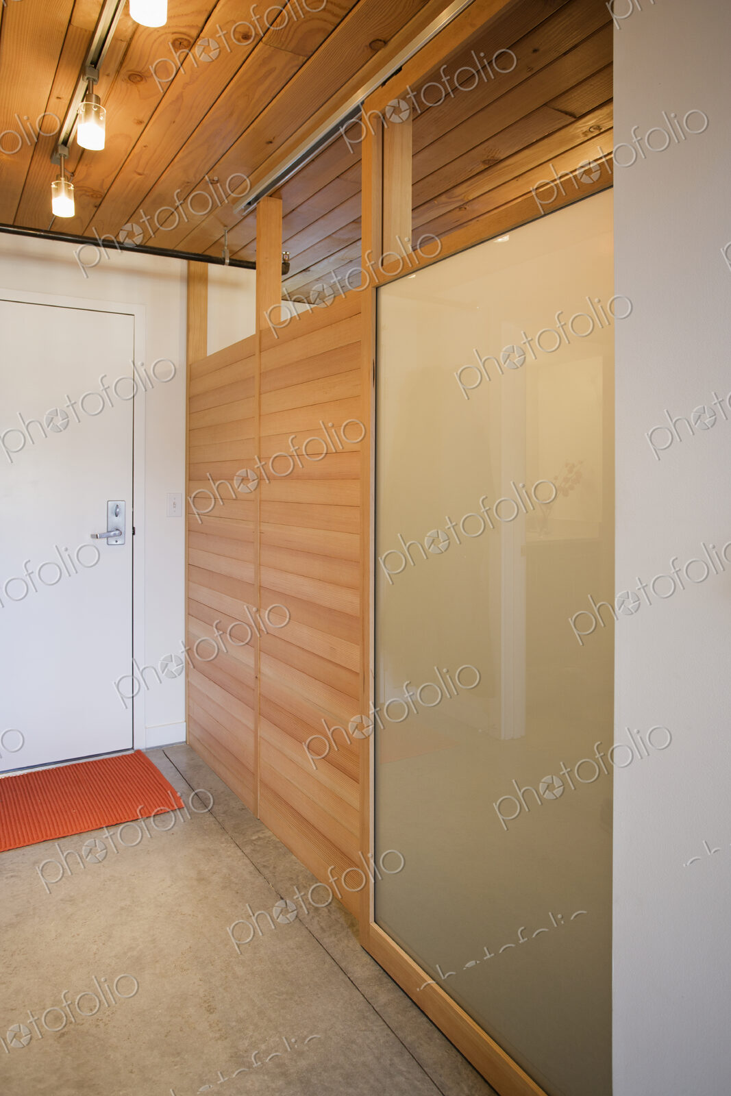 An empty room with a door and wooden partition with glass panes, and lights