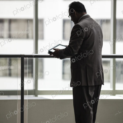 An hispanic businessman using a notebook computer in a convention center lobby.