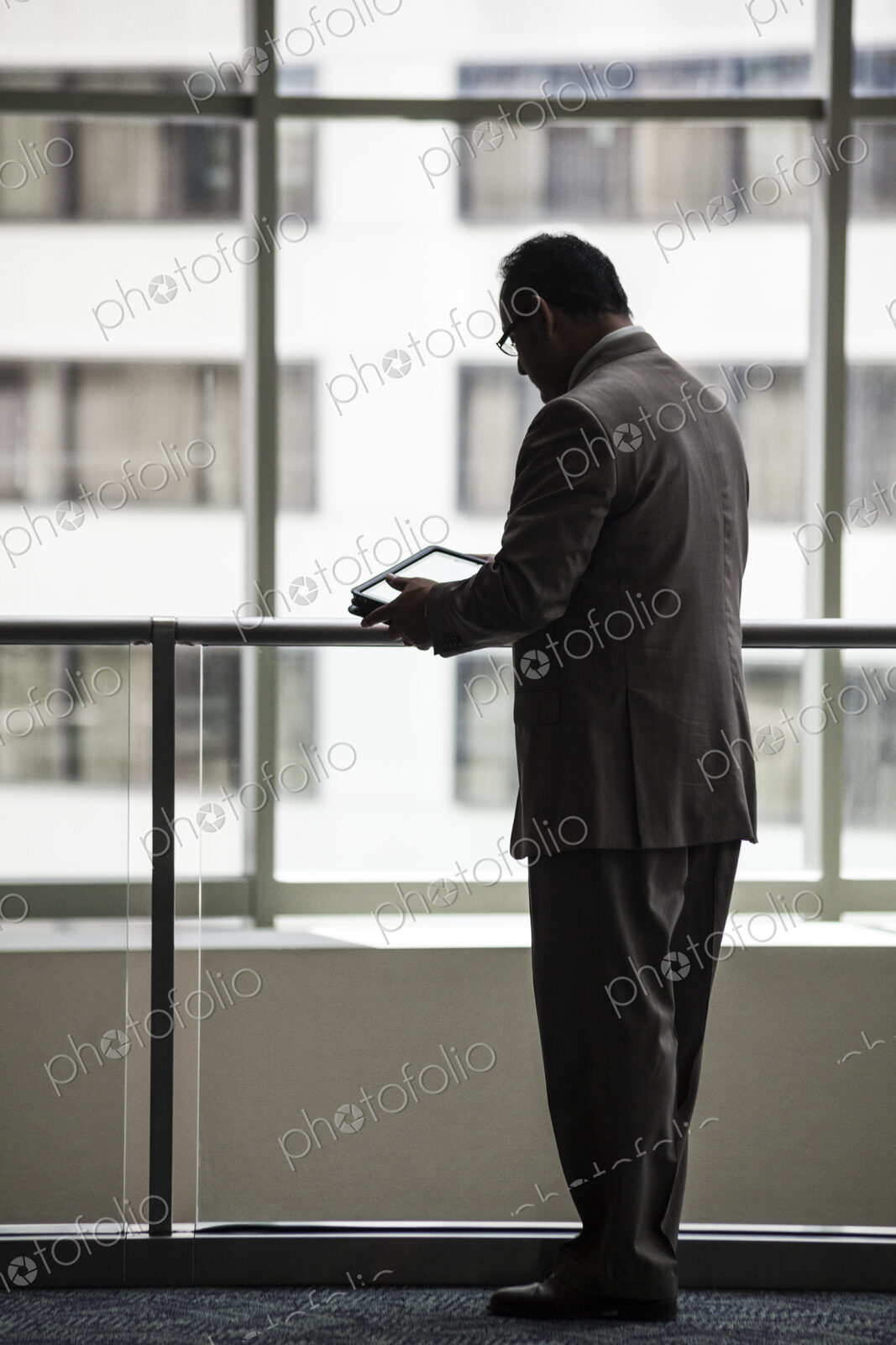 An hispanic businessman using a notebook computer in a convention center lobby.