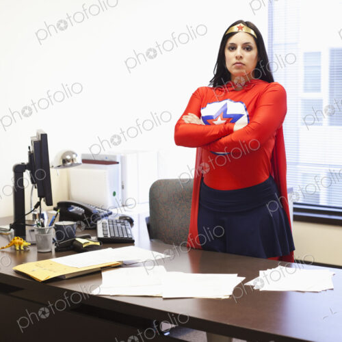 An hispanic businesswoman office super hero at her office computer An hispanic businesswoman office super hero at her office computer