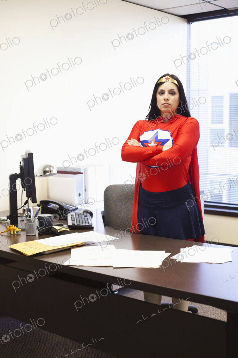 An hispanic businesswoman office super hero at her office computer