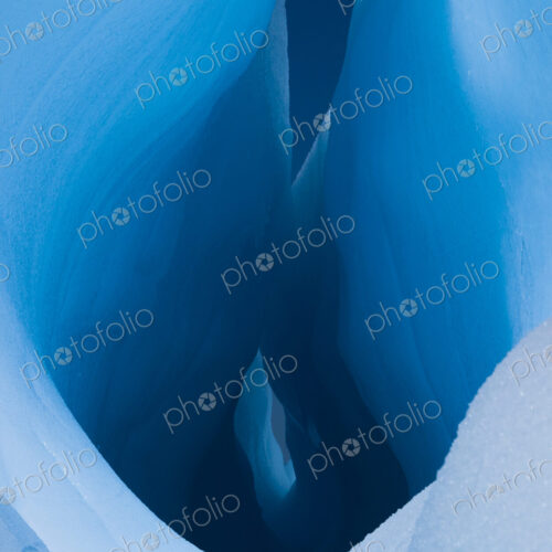 An iceberg with a deep crevasse or fissure, and the contours of melting ice, in… An iceberg with a deep crevasse or fissure, and the contours of melting ice, in…