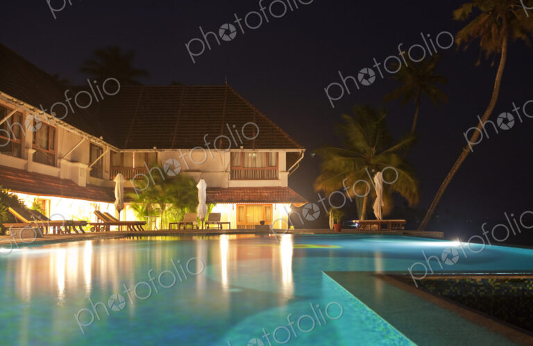 An infinity pool at night, on the terrace of a luxury hotel in Alleppey, Kerala India.
