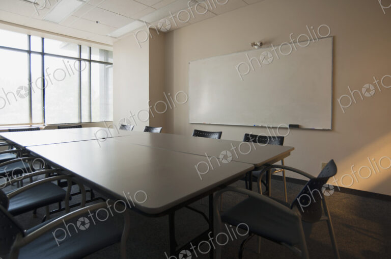 An office boardroom with table and chairs and a whiteboard on the wall.