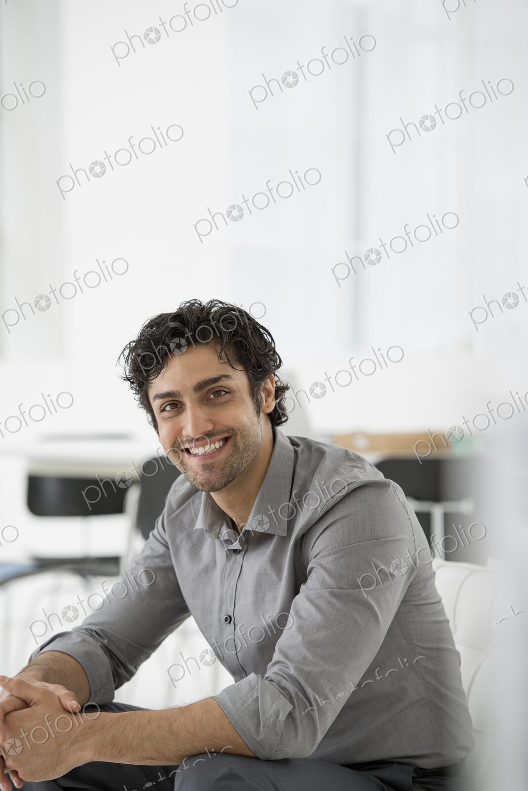 An office in the city. Business. A man seated with his hands clasped in a relaxed…