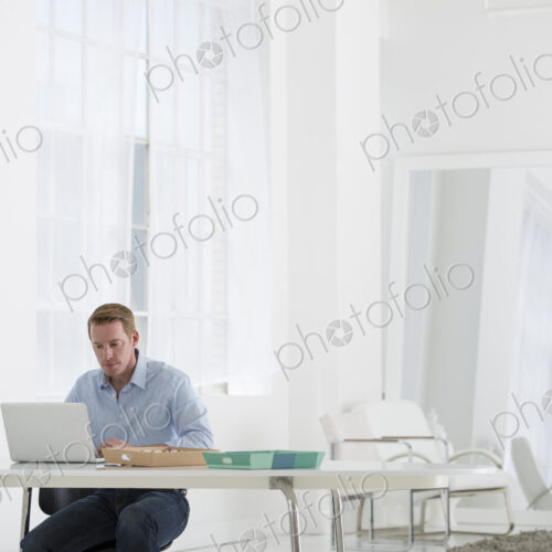 An office in the city. Business. A man sitting at a desk using a laptop. An office in the city. Business. A man sitting at a desk using a laptop.