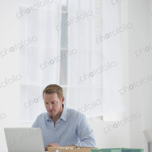 An office in the city. Business. A man sitting at a desk using a laptop. An office in the city. Business. A man sitting at a desk using a laptop.