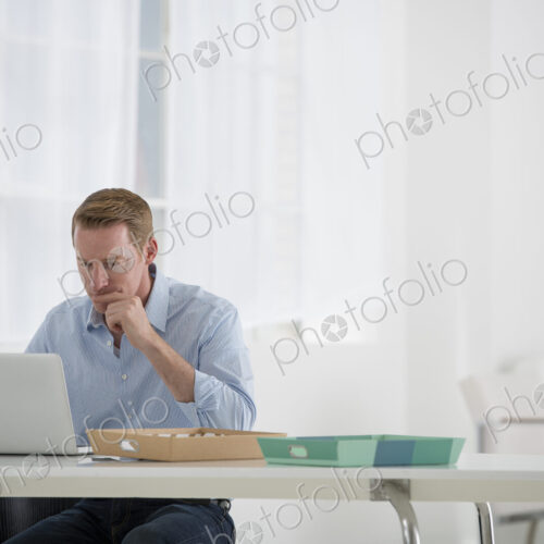 An office in the city. Business. A man sitting at a desk using a laptop. An office in the city. Business. A man sitting at a desk using a laptop.