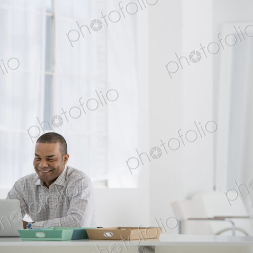 An office in the city. Business. A man sitting at a desk using a laptop. An office in the city. Business. A man sitting at a desk using a laptop.