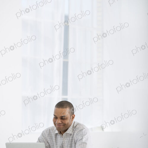 An office in the city. Business. A man sitting at a desk using a laptop. An office in the city. Business. A man sitting at a desk using a laptop.