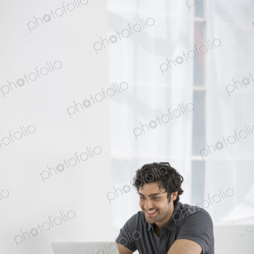 An office in the city. Business. A man sitting at a desk using a laptop.