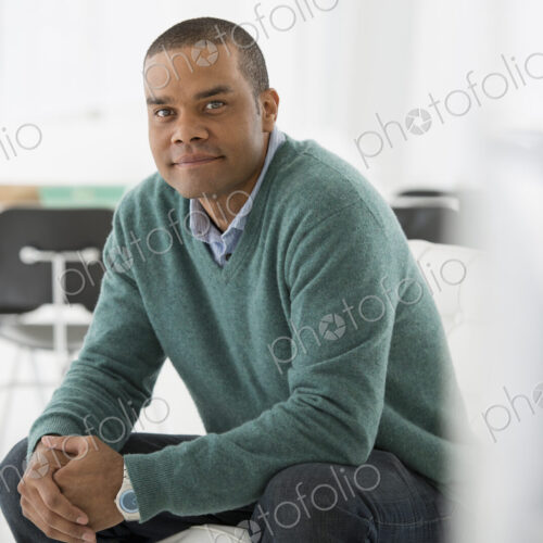 An office in the city. Business. A man sitting, hands clasped in a relaxed confident pose. An office in the city. Business. A man sitting, hands clasped in a relaxed confident pose.