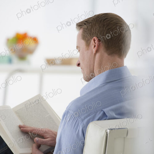An office in the city. Business. A man sitting holding a book in his hands. Reading.… An office in the city. Business. A man sitting holding a book in his hands. Reading.…