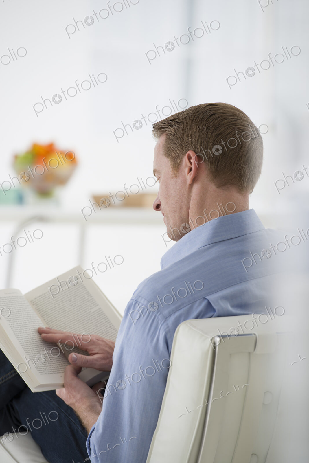 An office in the city. Business. A man sitting holding a book in his hands. Reading.…