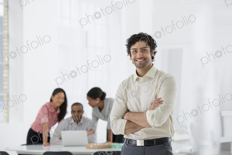 An office in the city. Business. A man standing with his arms folded, and three people…
