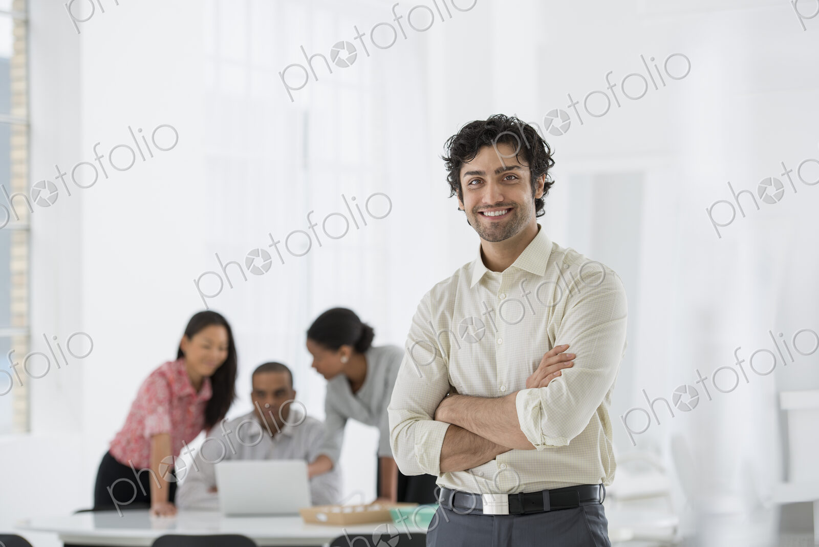 An office in the city. Business. A man standing with his arms folded, and three people…