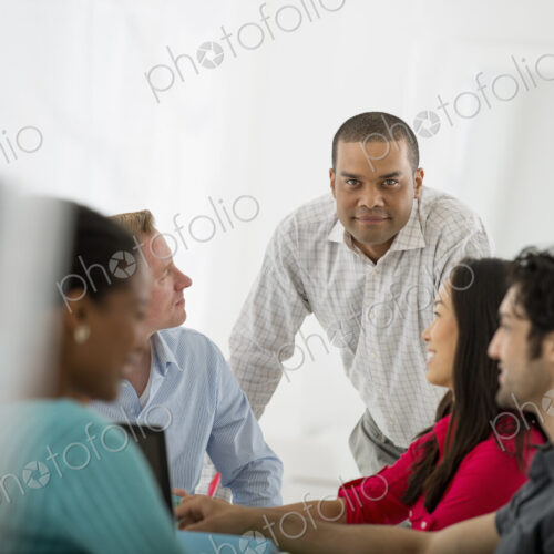 An office in the city. Business. A multi ethnic group of people around a table, men…