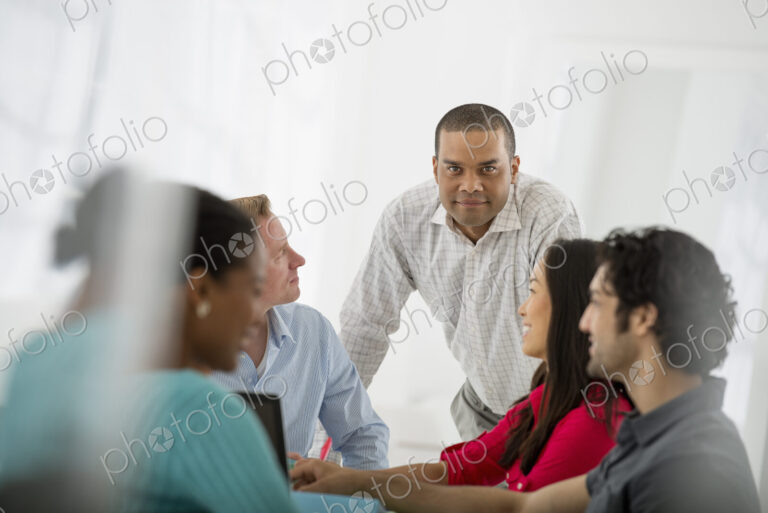 An office in the city. Business. A multi ethnic group of people around a table, men…