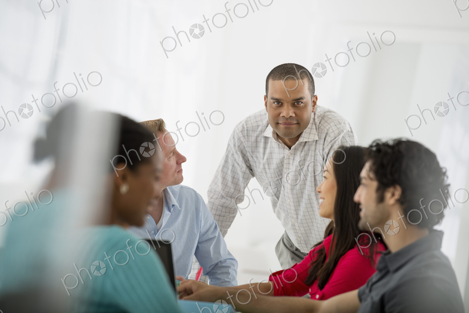 An office in the city. Business. A multi ethnic group of people around a table, men…