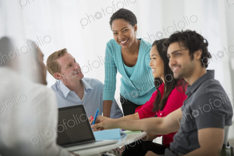 An office in the city. Business. A multi ethnic group of people around a table, men…