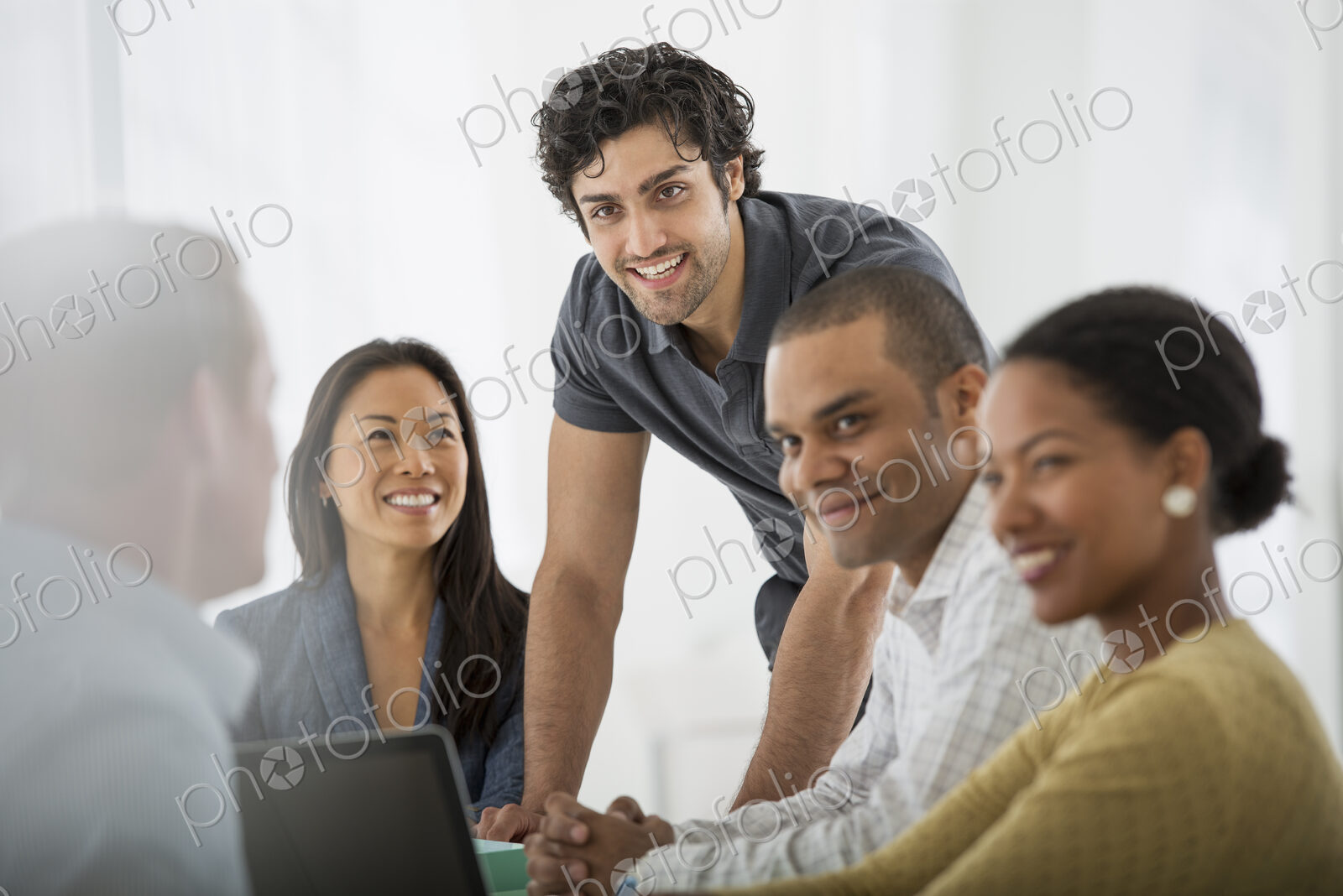 An office in the city. Business. A multi ethnic group of people around a table, men…
