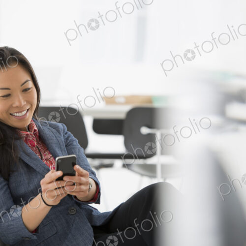 An office in the city. Business. A woman seated in a comfortable chair, checking her… An office in the city. Business. A woman seated in a comfortable chair, checking her…