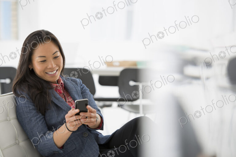 An office in the city. Business. A woman seated in a comfortable chair, checking her…