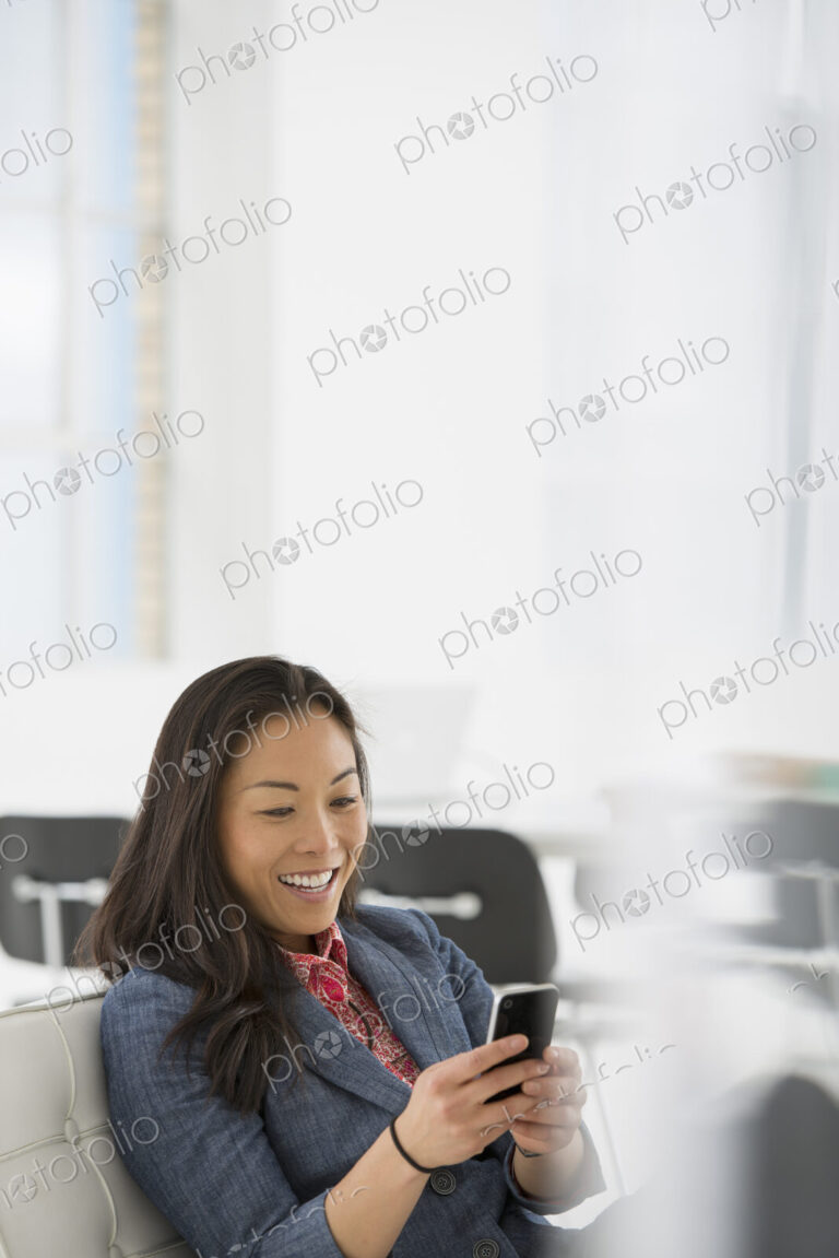 An office in the city. Business. A woman seated in a comfortable chair, checking her…