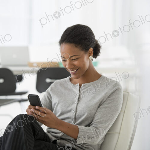 An office in the city. Business. A woman seated in a comfortable chair, checking her…