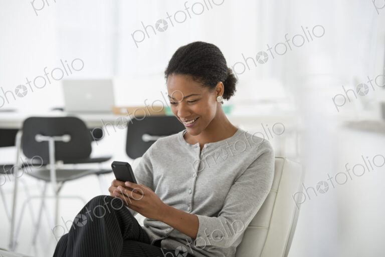 An office in the city. Business. A woman seated in a comfortable chair, checking her…