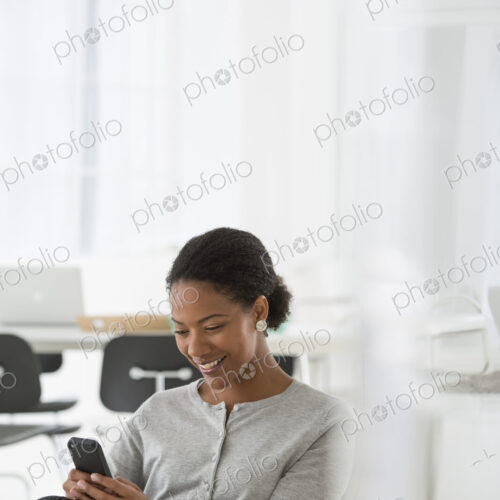 An office in the city. Business. A woman seated in a comfortable chair, checking her…