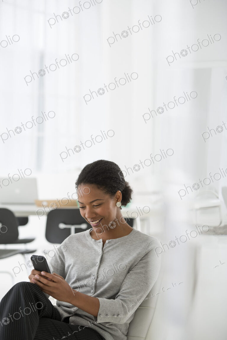 An office in the city. Business. A woman seated in a comfortable chair, checking her…